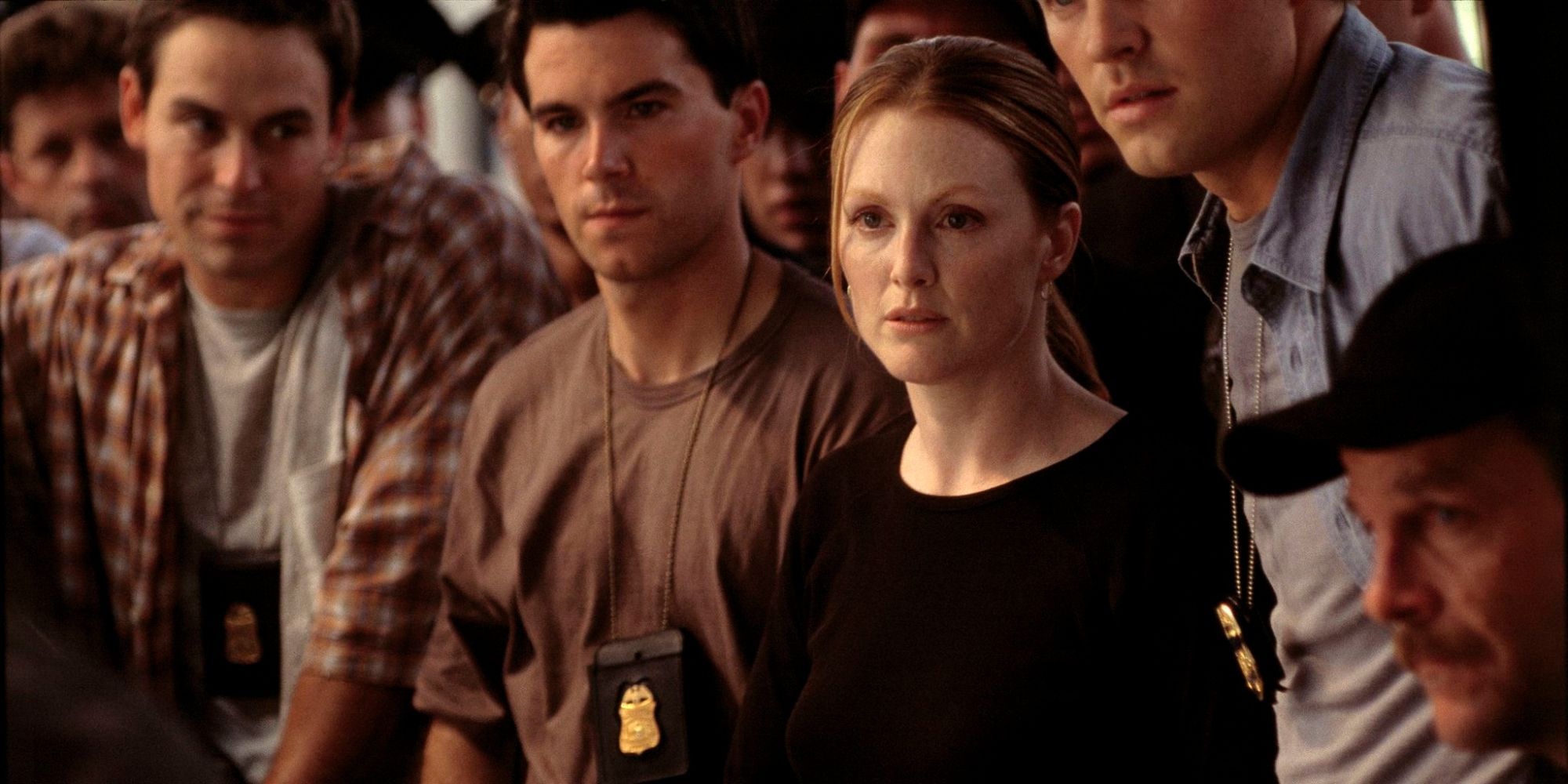 Clarice Starling, played by Julianne Moore, standing in front of a team of male agents in the Hannibal movie