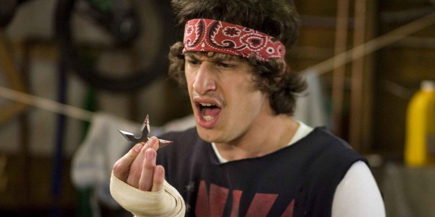 Andy Samberg as Rod Kimble holding a bloody ninja star in pain in Hot Rod