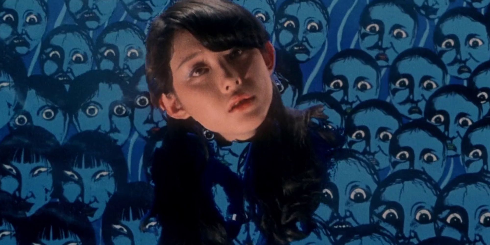 Miki Jinbo as a severt head floating with a background of painted faces in House (1977)