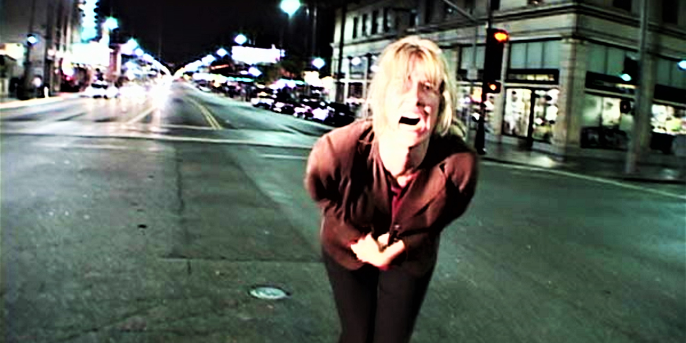 Laura Dern hunched over screaming in the middle of a deserted street in Inland Empire