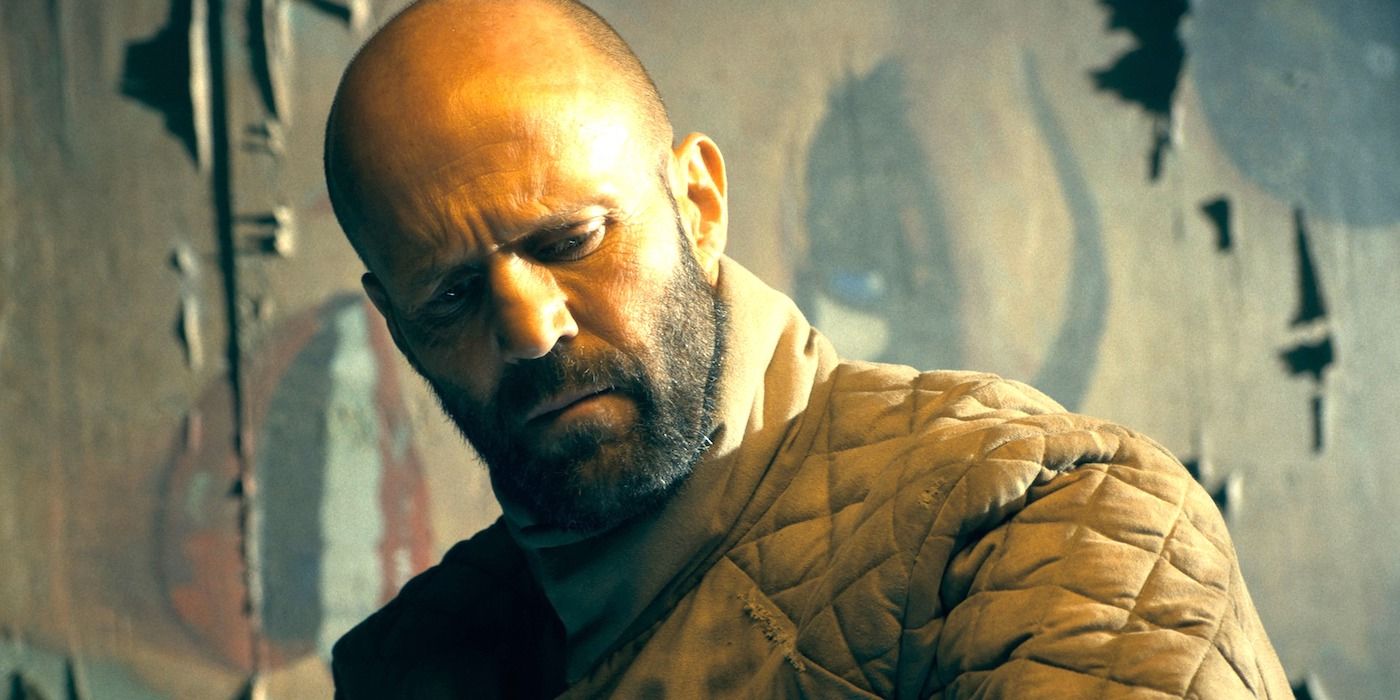 A bearded Jason Statham as Adam Clay looking down to survey a scene in The Beekeeper.