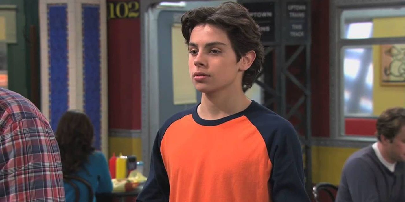 Jake T. Austin as Max Russo standing in the family shop in Wizards of Waverly Place