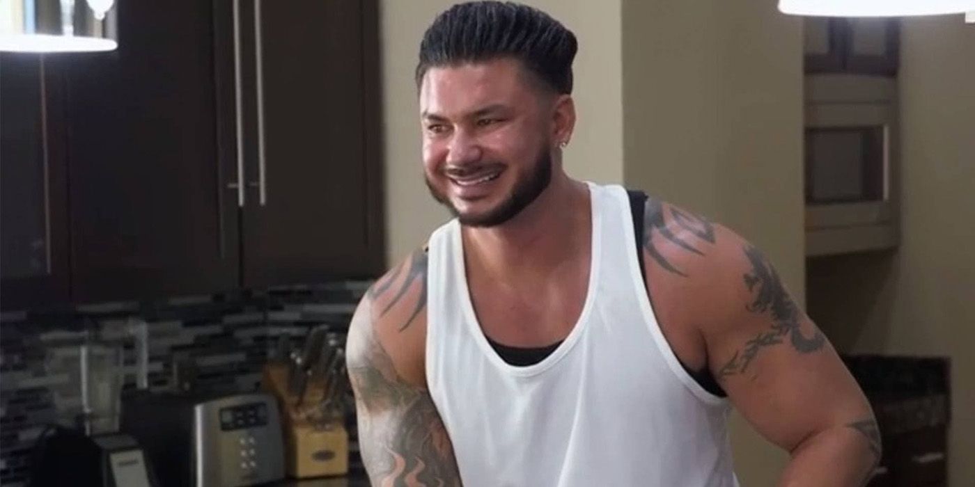 Pauly D from Jersey Shore standing in a kitchen smiling, wearing a white tank top.