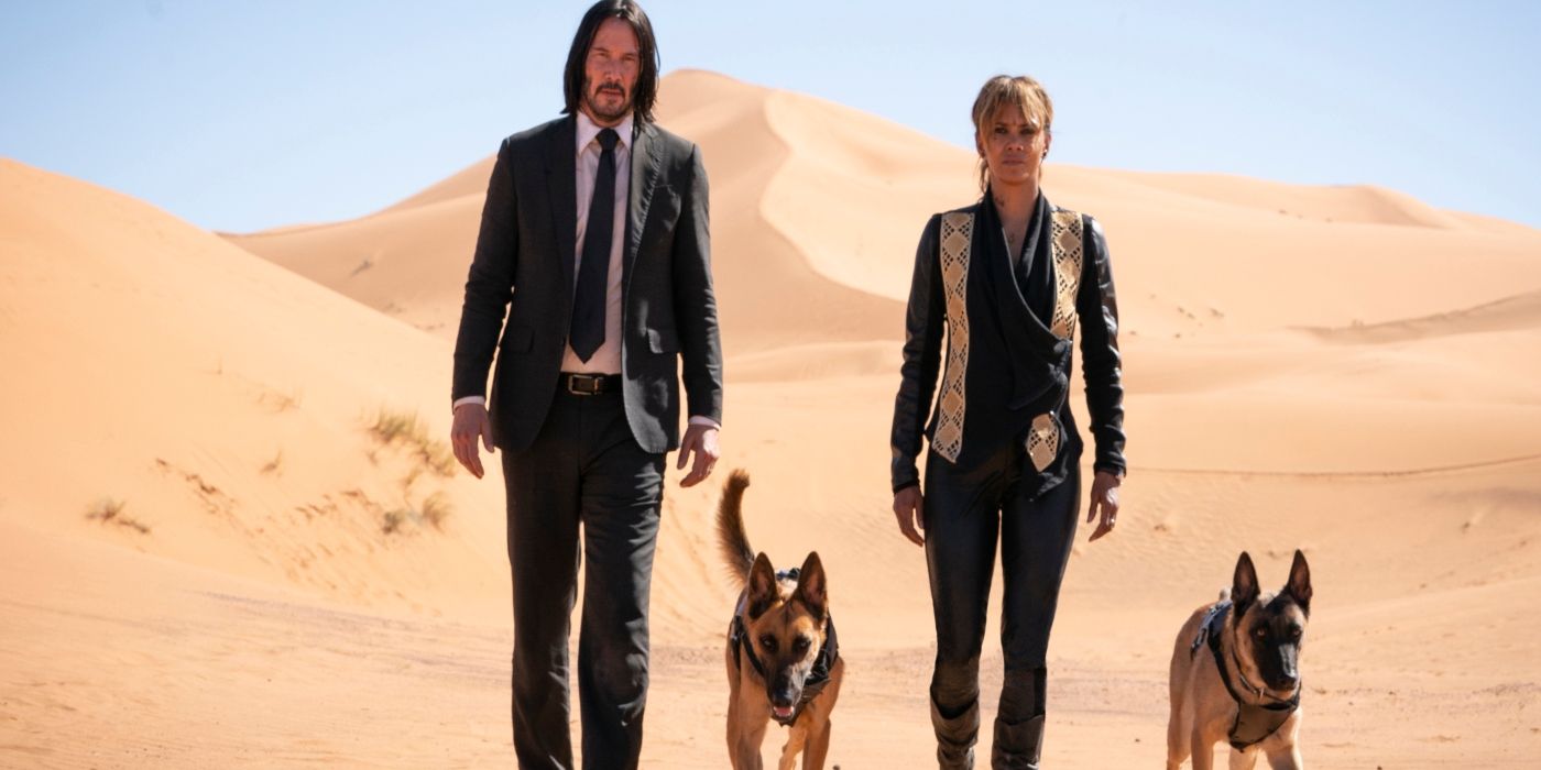 John Wick and Sofia Al-Azwar walking through the desert with two German Sheperds in John Wick 3