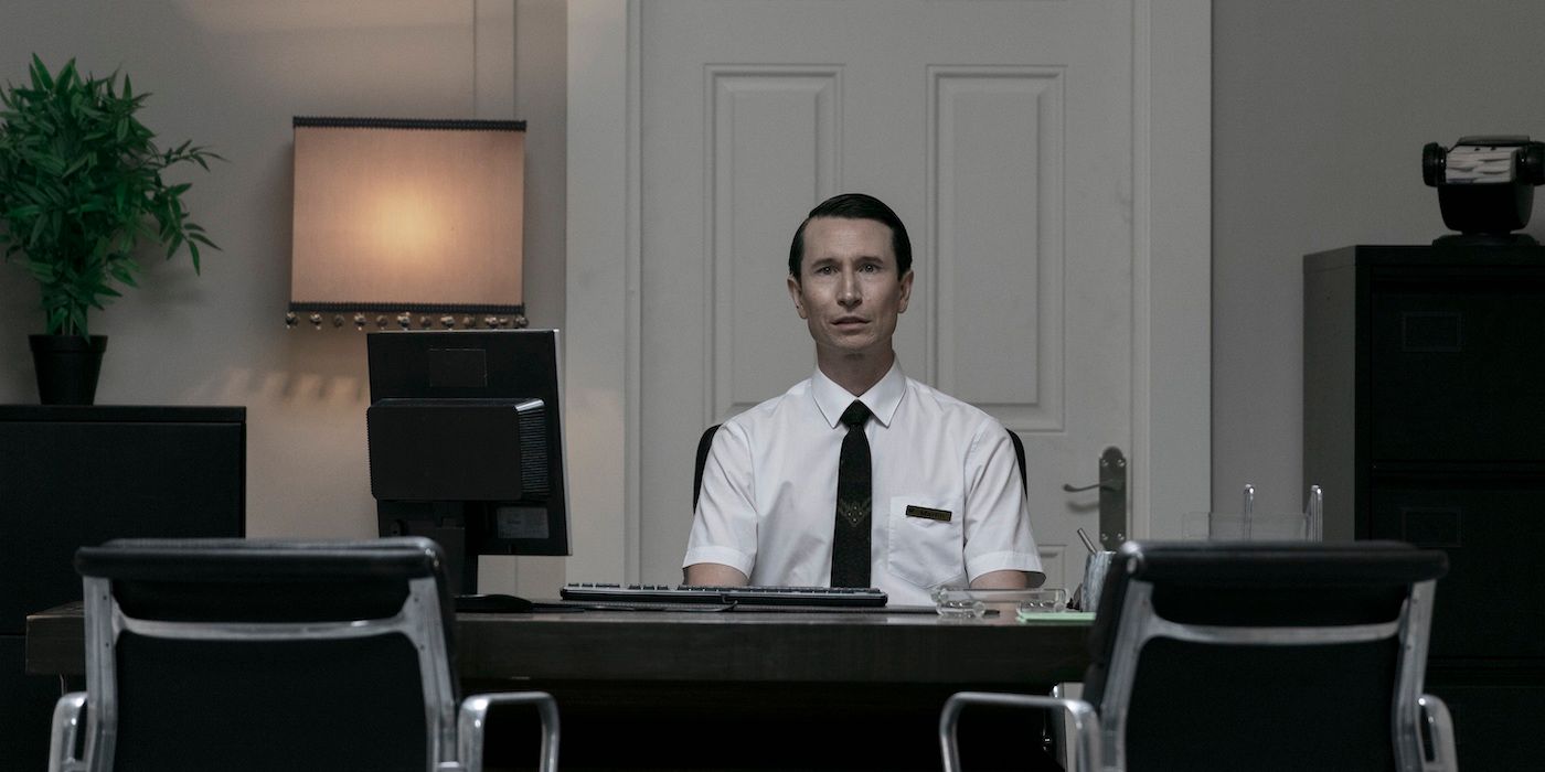 Jonathan Aris as Martin sitting at a desk in Vivarium