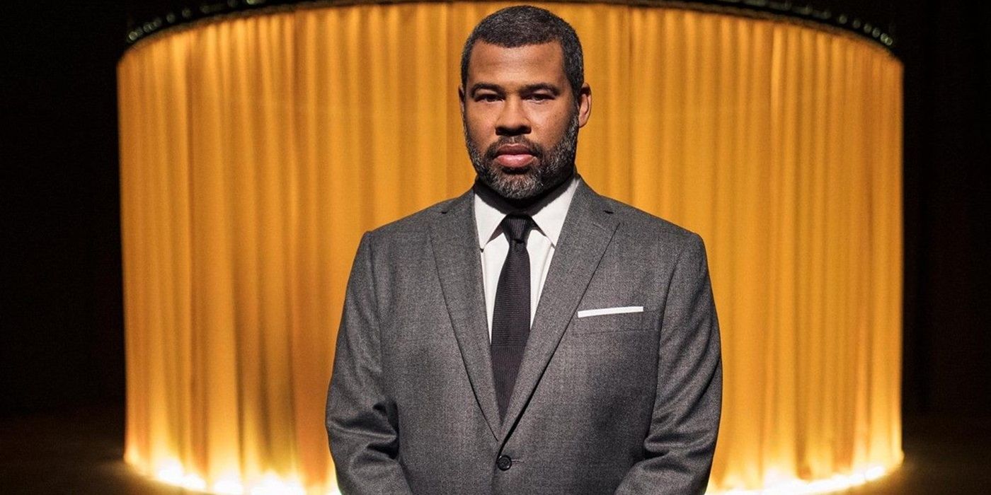 Jordan Peele wearing a grey suit and tie while hosting an episode of The Twilight Zone