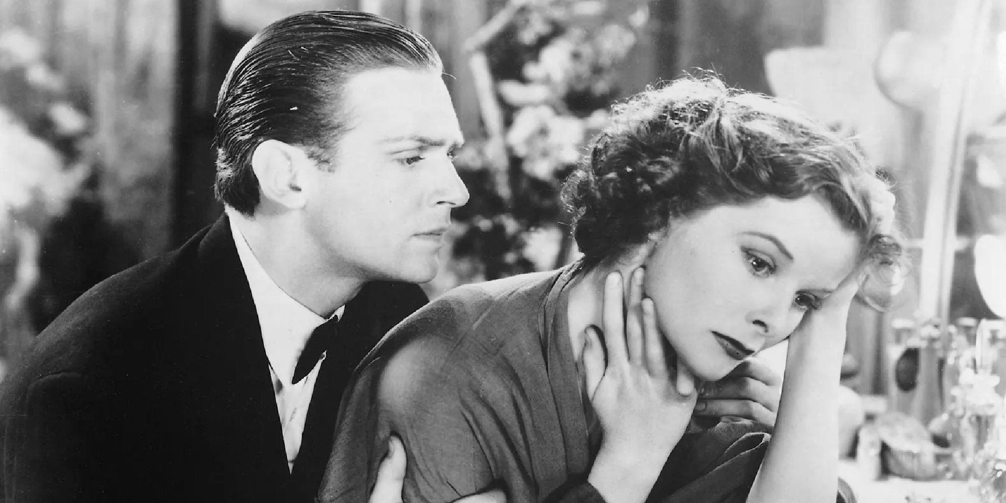 Joseph (Douglas Fairbanks Jr.) leaning on Eva (Katharine Hepburn) while she looks worried in Morning Glory