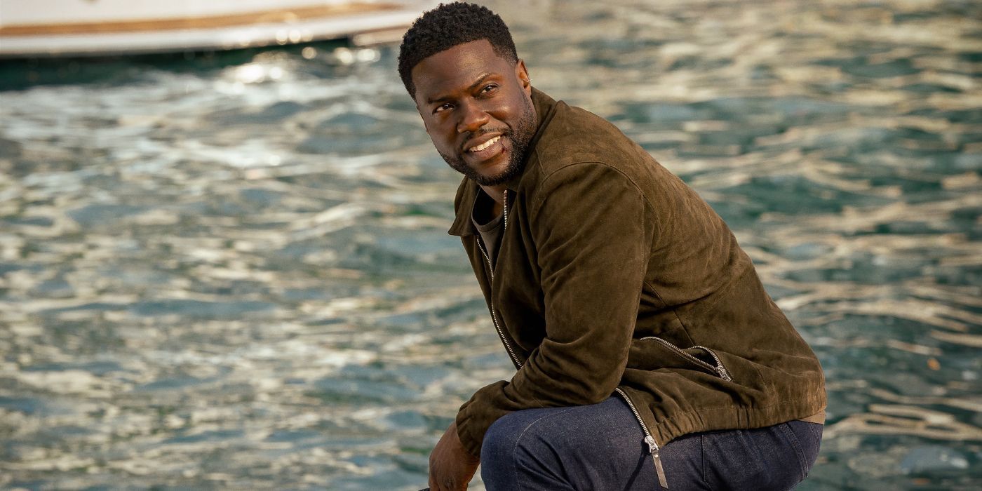 Kevin Hart as Cyrus, smiling, while crouching down on a dock