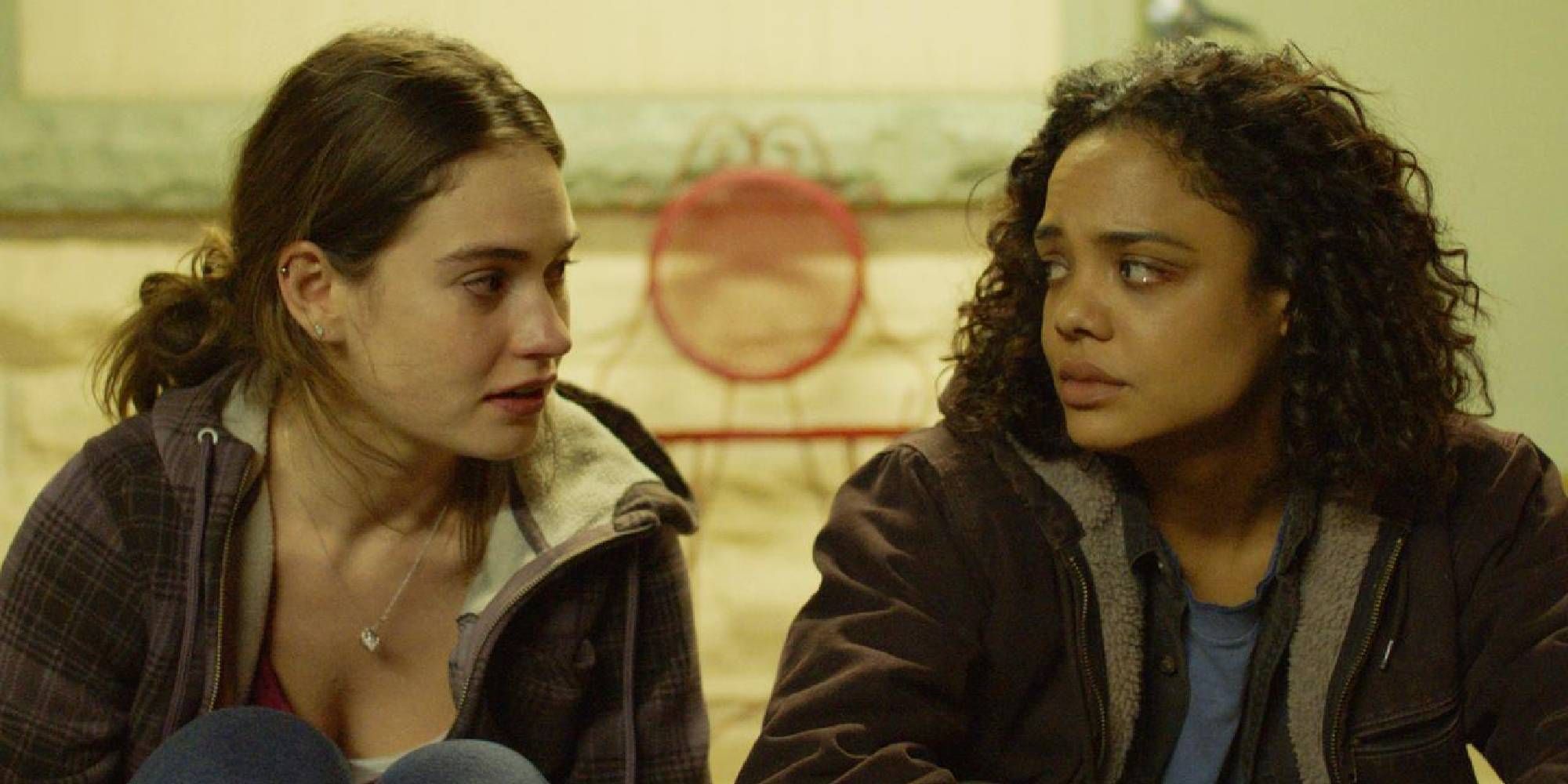 Lily James and Tessa Thompson as Deb and Ollie Hale, sitting and looking at each other sadly in Little Woods