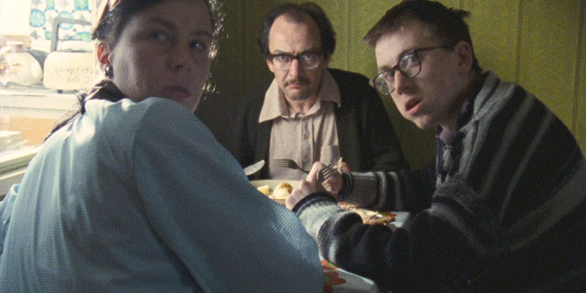 Tim Roth, Pam Ferris, and Jeffrey Robert as Colin, Mavis, and Frank, eating in a restaurant in Meantime