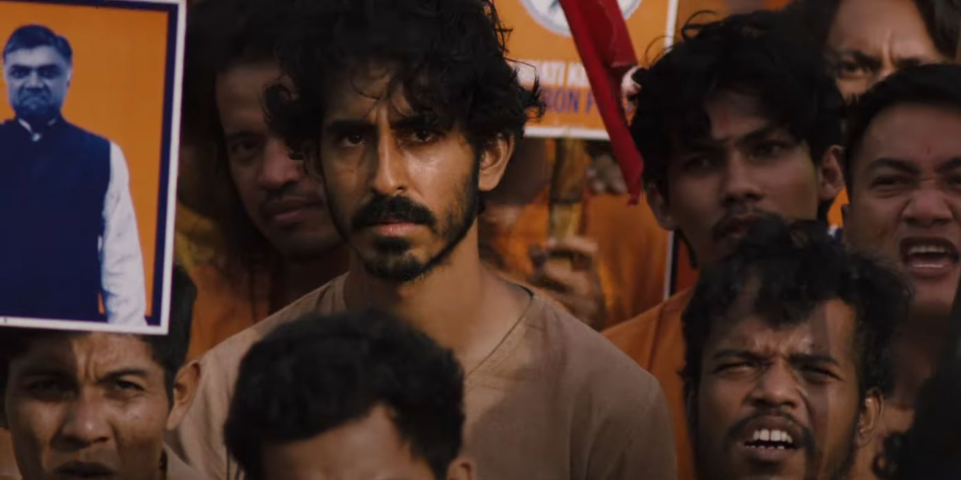 Dev Patel as Kid, standing alongside a group of political protestors in Monkey Man