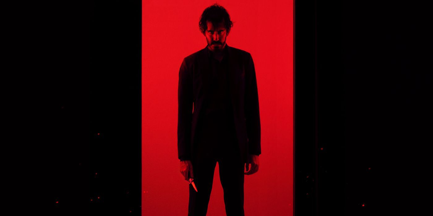 Dev Patel stands against a red background and holds a knife on the poster for Monkey Man