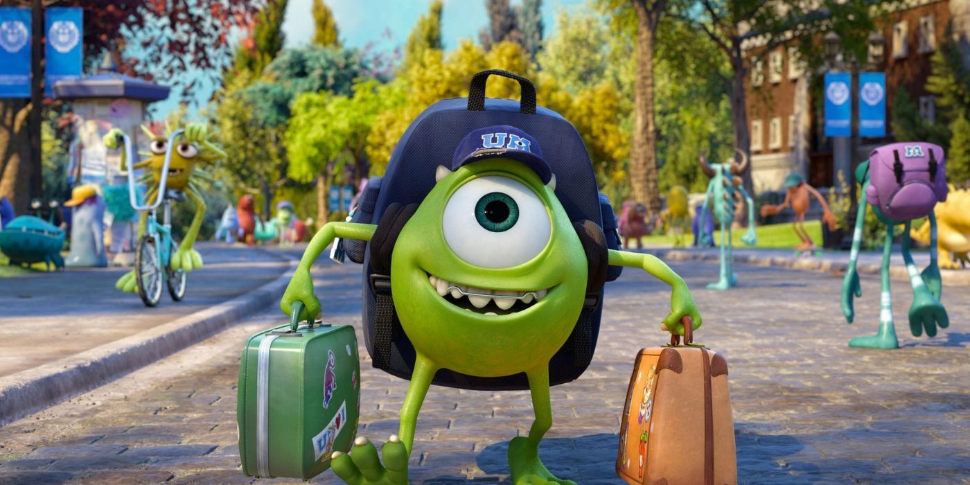 Mike walking onto campus, holding two suitcases, wearing a backpack, and smiling