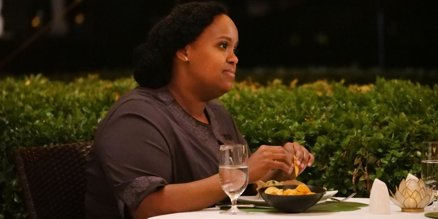 Belinda Lindsey (Natasha Rothwell) sitting a table in The White Lotus Season 1