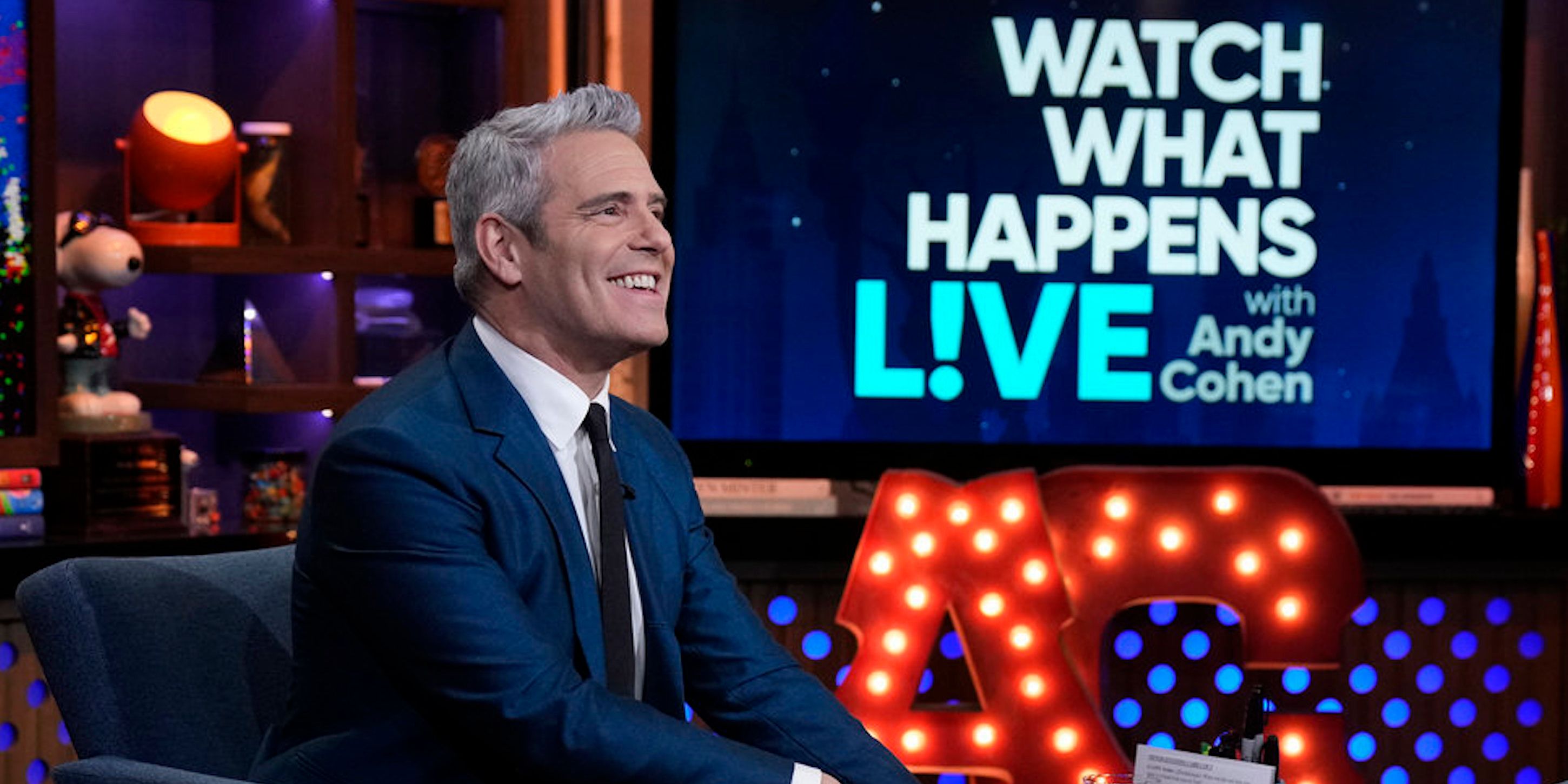 Andy Cohen smiling in his seat on the 'Watch What Happens Live'