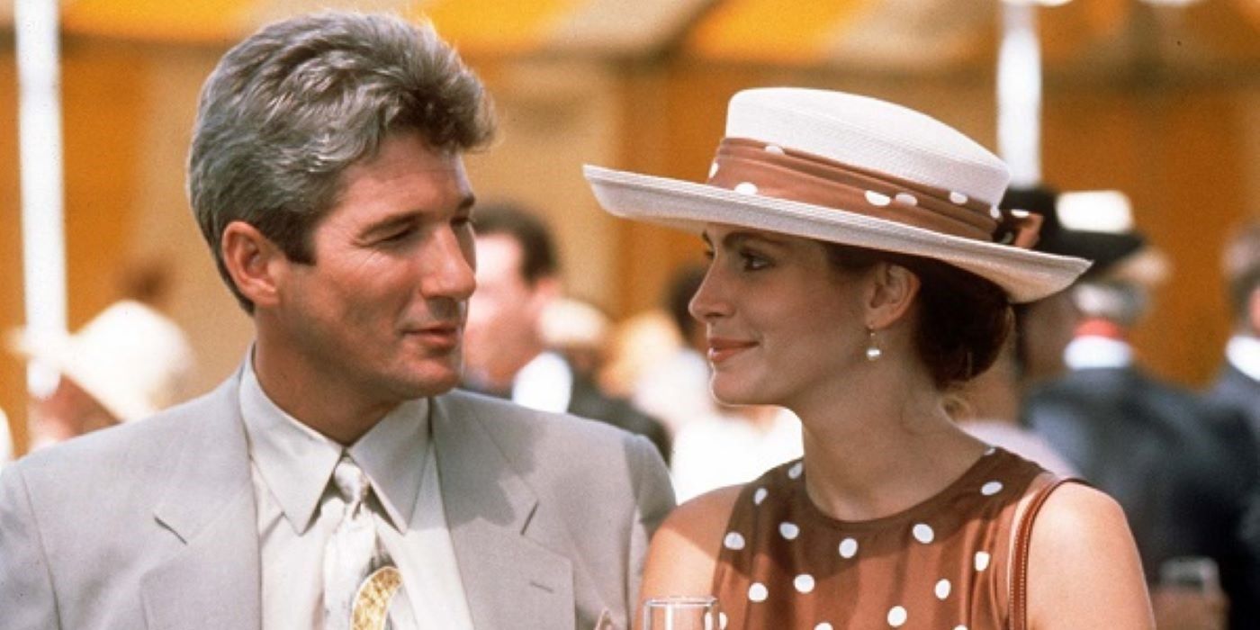 Richard Gere and Julia Roberts smiling at each other at a garden party in Pretty Woman