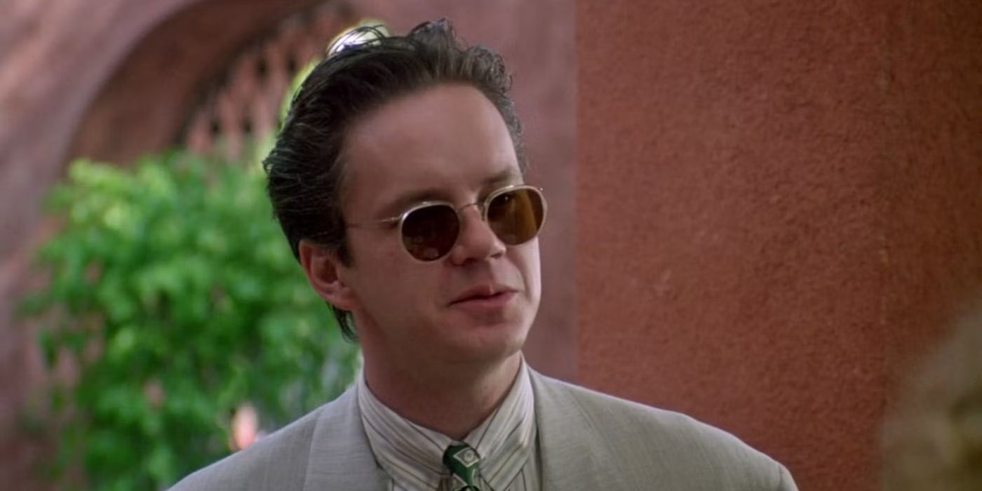 Tim Robbins as Griffin Mill, wearing sunglasses and talking to someone offscreen in The Player