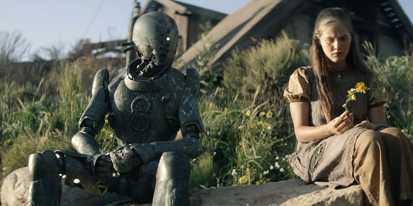 The humanoid robot Jimmy, voiced by Anthony Hopkins, and Sam, a human girl played by Charlotte Maggie, sit on a rock and talk in Rebel Moon.