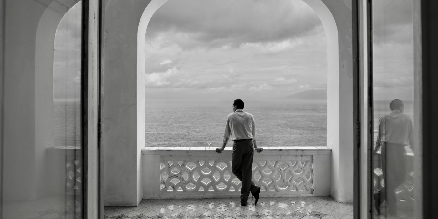 Andrew Scott as Tom Ripley, looking out at the ocean, with his back to the camera, in Ripley