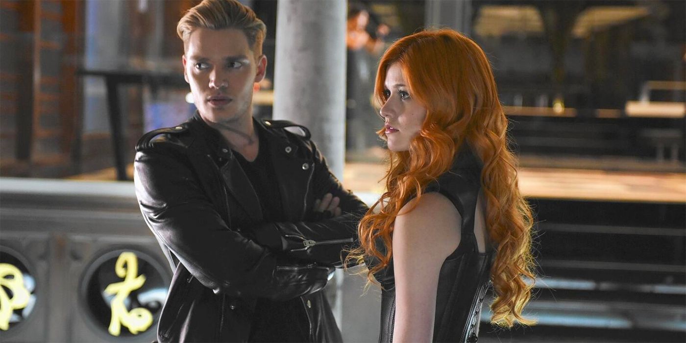 Katherine McNamara as Clary and Dominic Sherwood as Jace standing next to each other in Shadowhunters