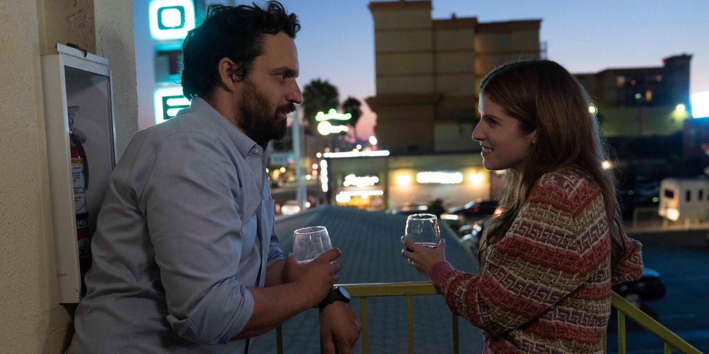 Jake Johnson and Anna Kendrick as Tommy and Maddy, drinking wine on a balcony in Self Reliance