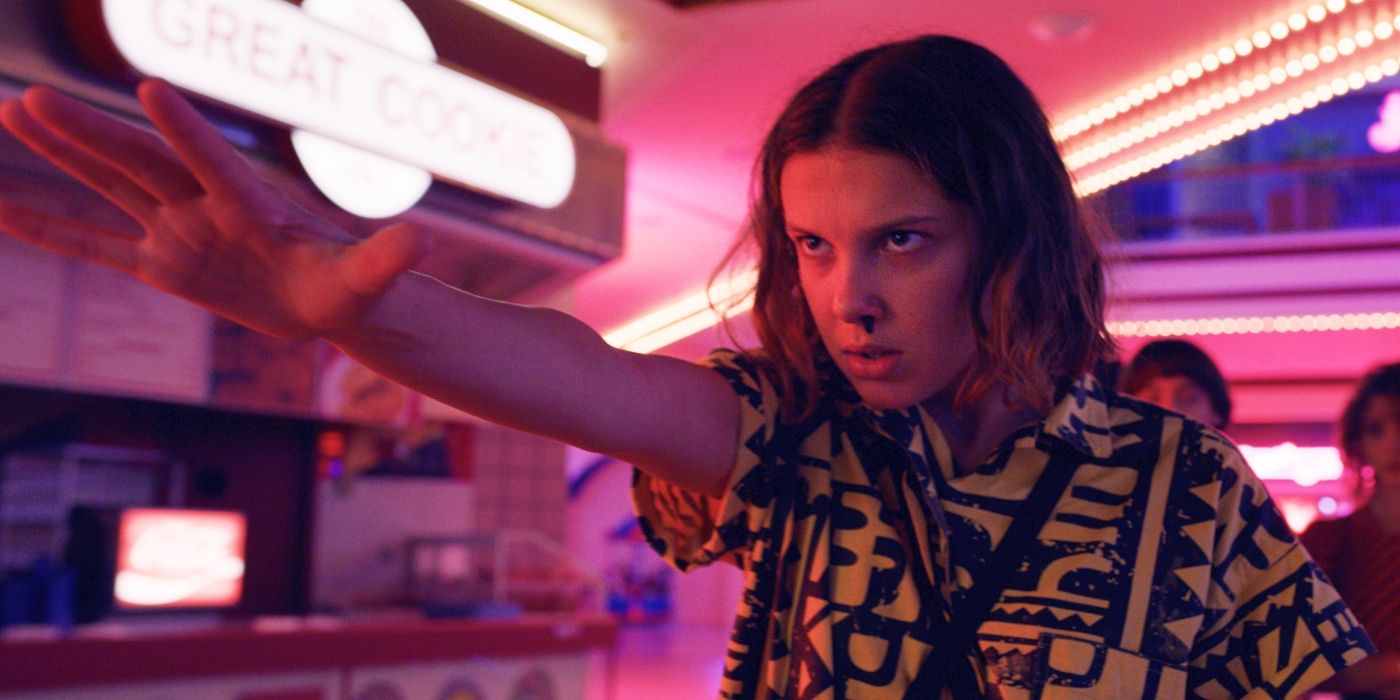 Millie Bobby Brown as  Eleven with her arm outstretched in Stranger Things