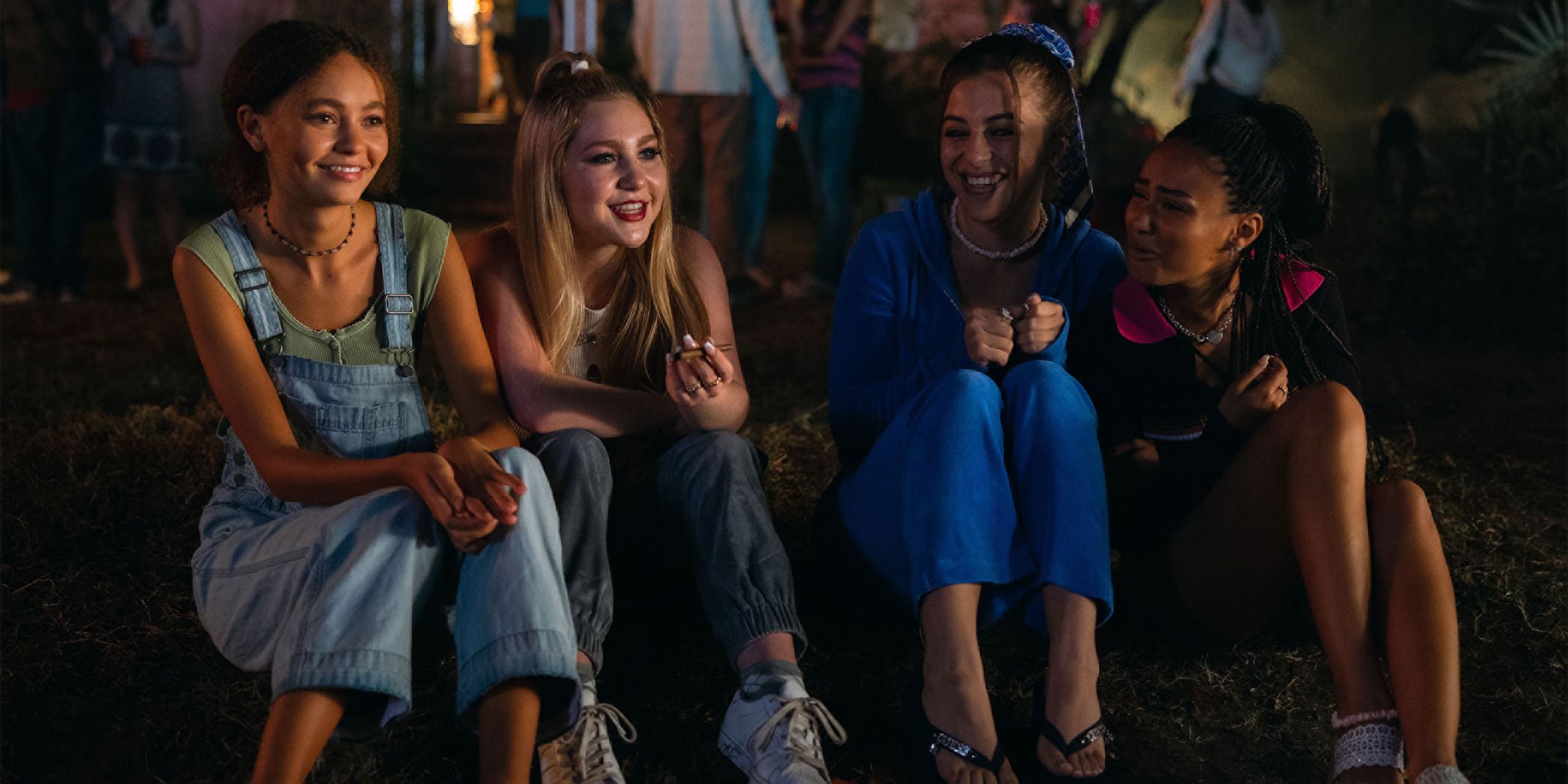 (from left to right) Nico Parker, Ella Anderson, Ariel Martin, and Daniella Taylor sitting on a curb laughing in Suncoast by Laura Chinn for Sundance 2024