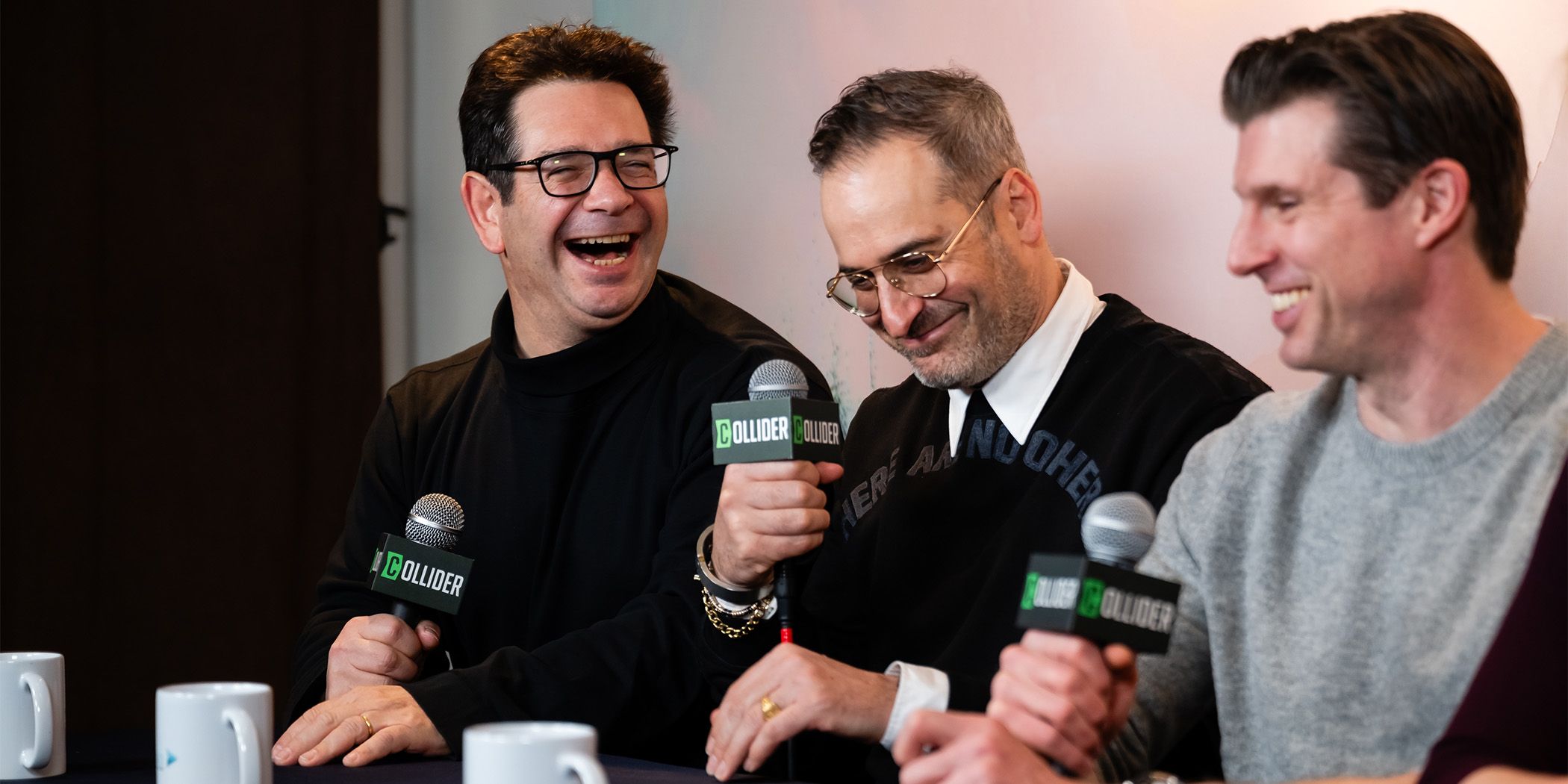 Super/Man: The Christopher Reeve Story's Peter Ettedgui, Ian Bonhôte, and Matthew Reeve laughing in an interview at Sundance 2024
