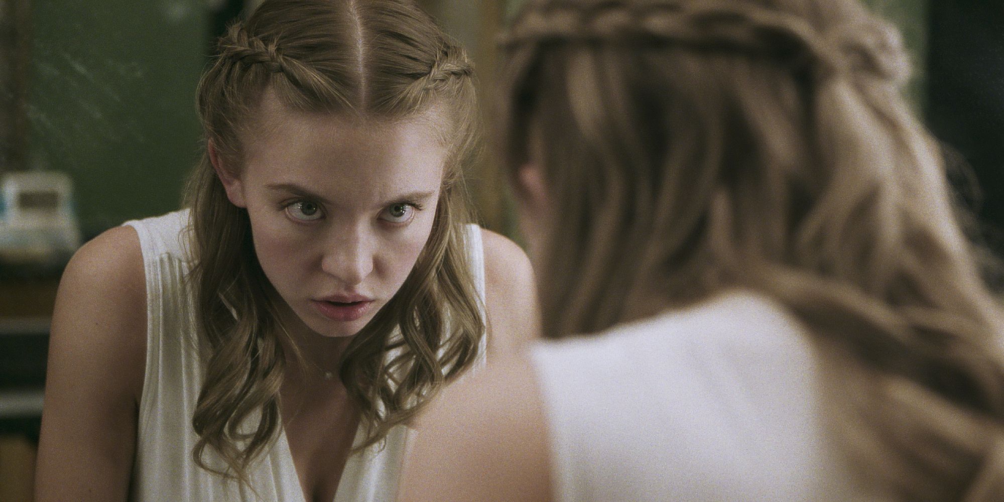 A close-up shot of Sydney Sweeney looking at herself in the mirror in Nocturne