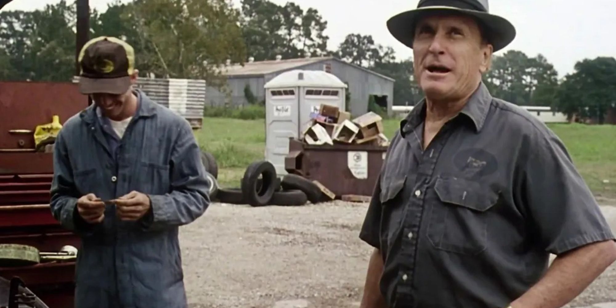 Robert Duvall as Euliss F. "Sonny" Dewey, standing outside with another man and laughing in The Apostle