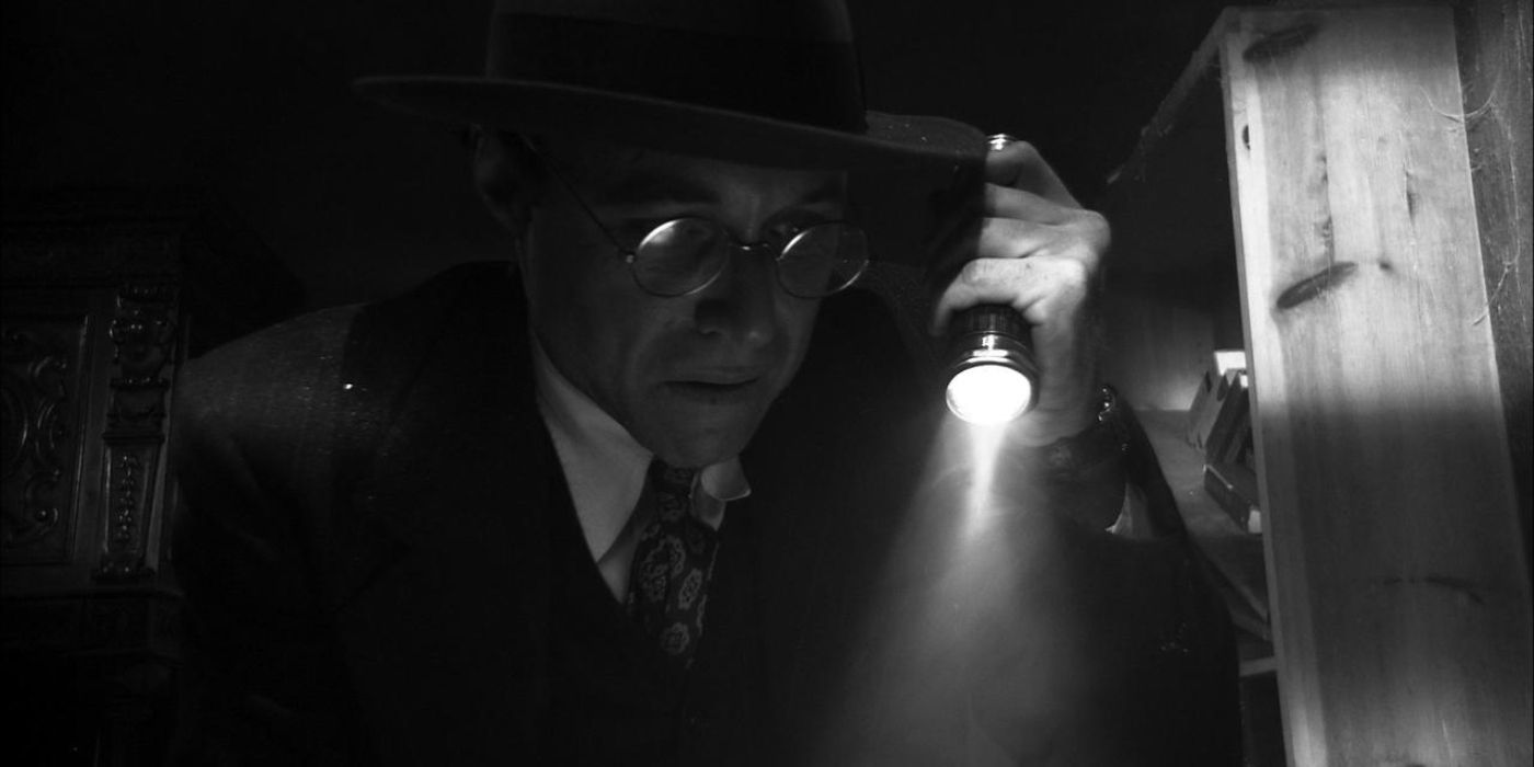 A man uses a flashlight as he searches through an old room for something.