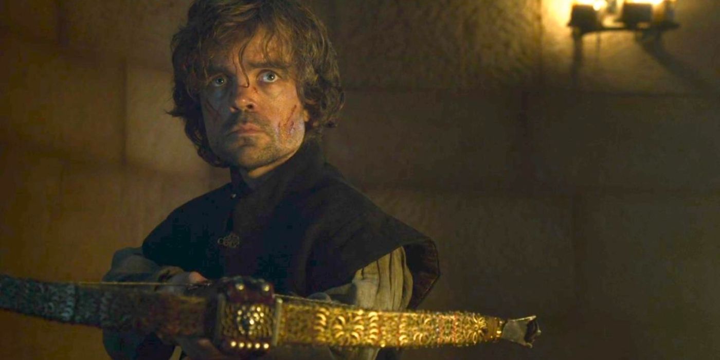 Tyrion Lannister stands in a brick hall, holding a crossbow with an angry look on his scratched face.