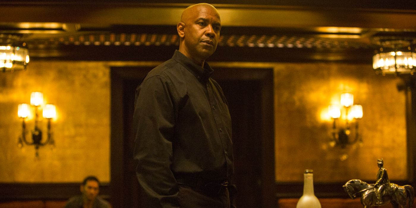 Denzel Washington as Robert McCall in a black shirt standing in a decadent room in 'The Equalizer'.