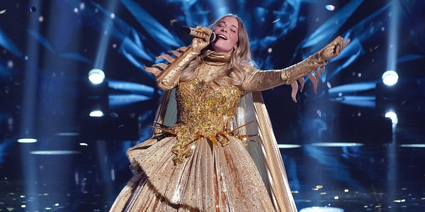 LeAnn Rimes singing as Sun on The Masked Singer, head up and eyes closed.