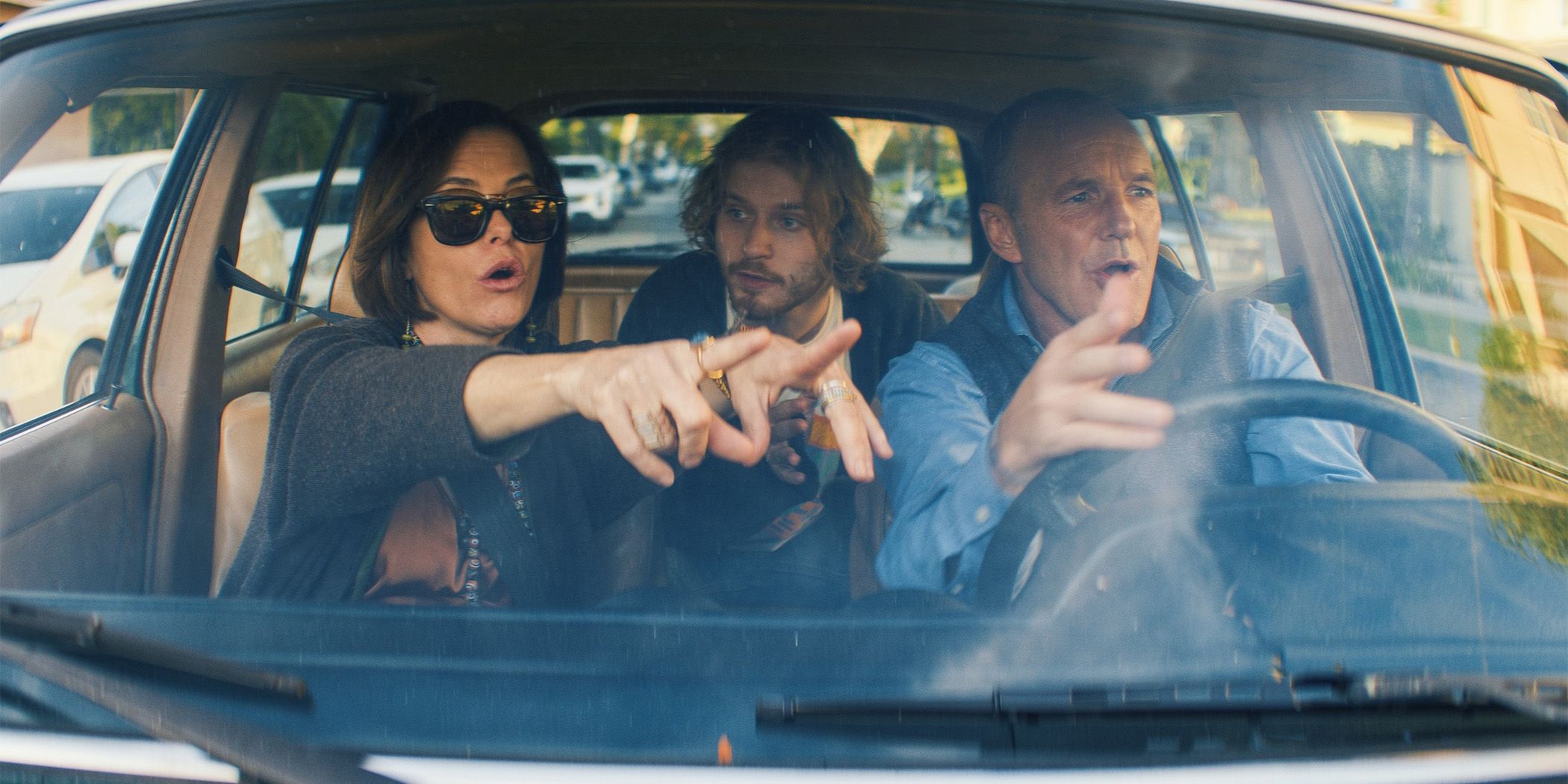 Parker Posey (left) pointing something out to Fred Hechinger (center) and Clark Gregg (left) in a car in Thelma for Sundance 2024