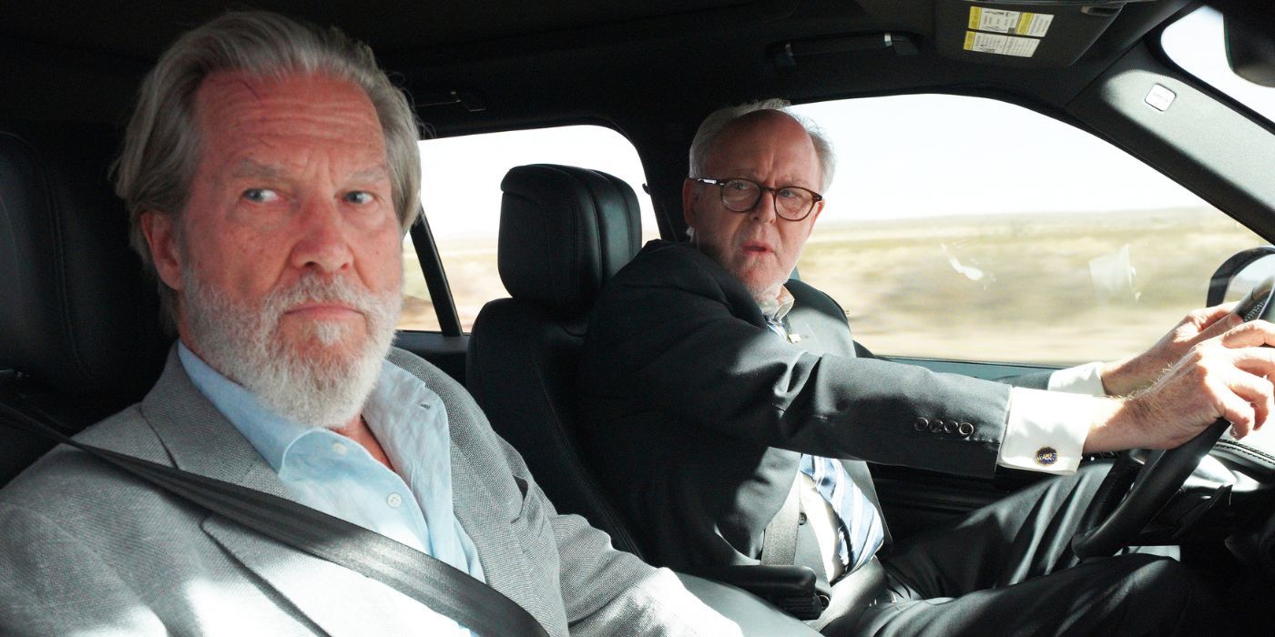 Dan Chase (Jeff Bridges) sitting in a passenger seat as Harold Harper (John Lithgow) drives in The Old Man