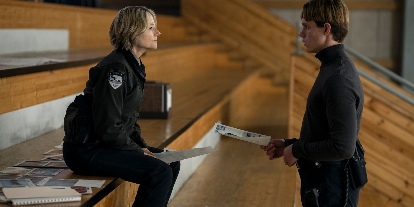 Jodie Foster and Finn Bennett talking on the bleachers at the ice rink in True Detective: Night Country