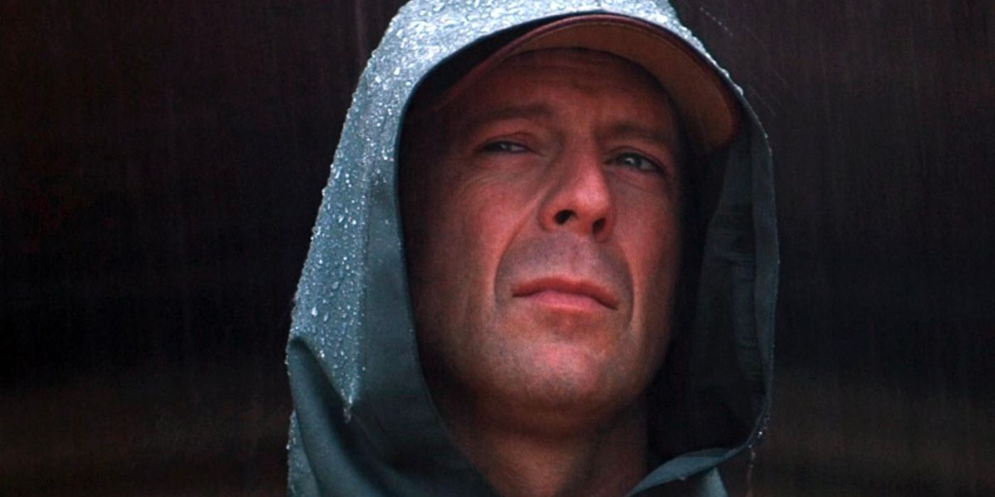 David Dunn (Bruce Willis) stands frowning in the rain with a water jacket on.