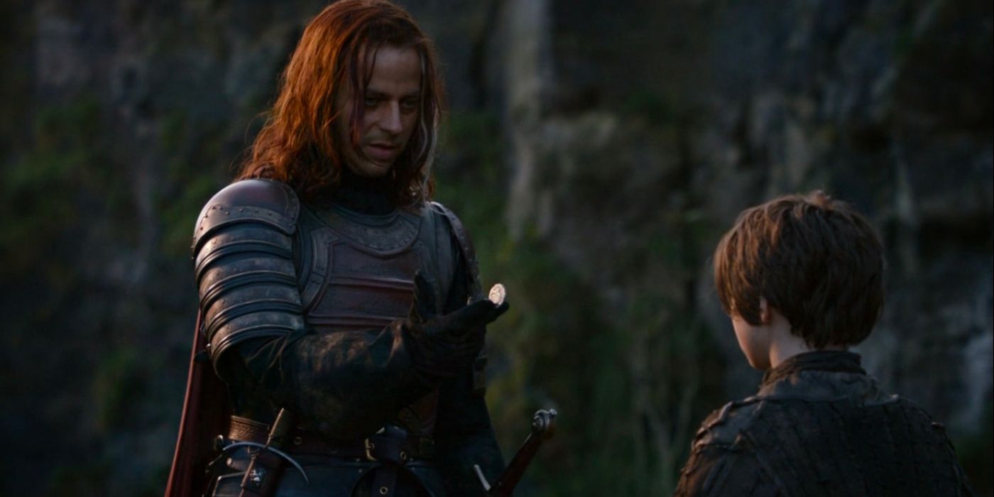 Jaqen H'ghar, dressed as a Lannister soldier, hands Arya Stark a coin. 