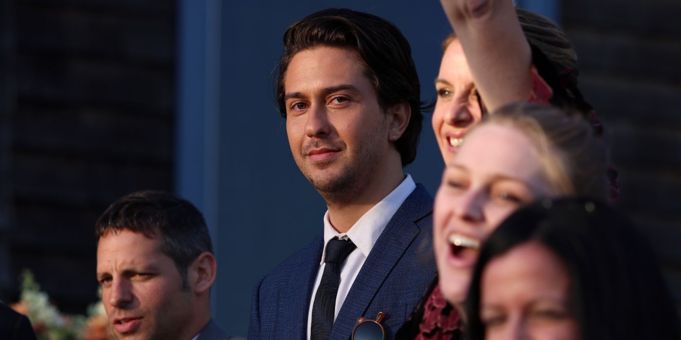 Nat Wolff in 'Which Brings Me to You' wearing a suit at a wedding.