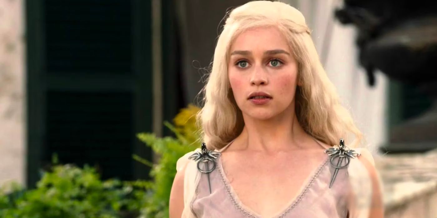 Daenerys Targaryen (Emilia Clarke) stands in a courtyard wearing a light summer dress.