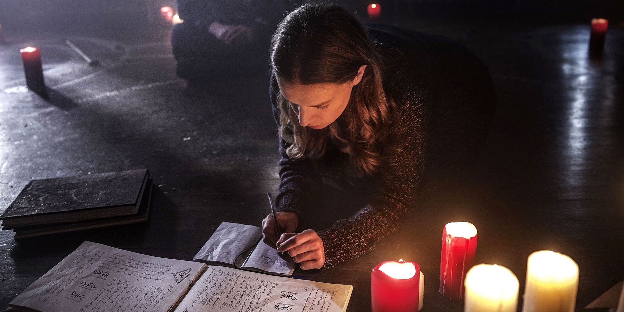 Catherine Walker as Sophia Howard painting symbols by candlelight in A Dark Song