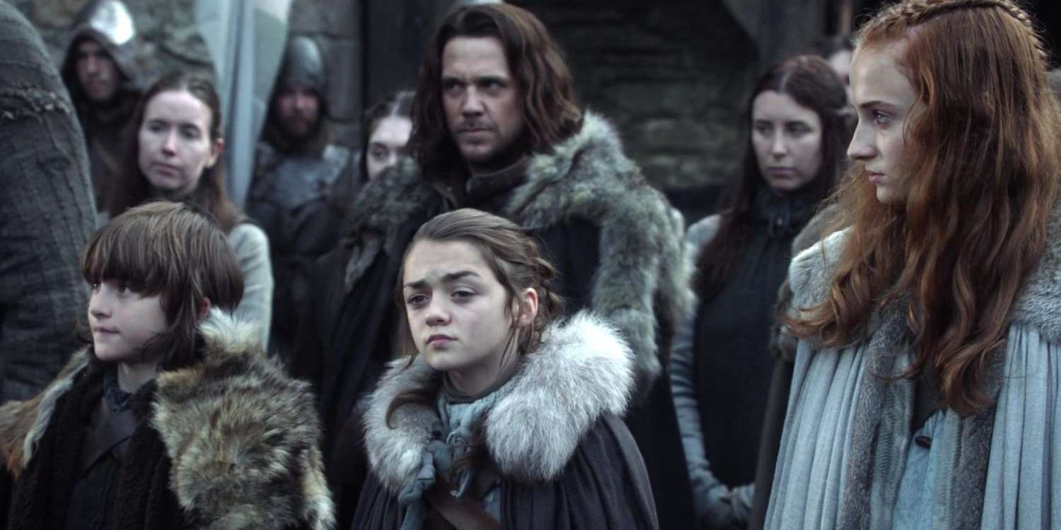 Maisie Williams as Arya Stark, standing with Sansa and Bran 