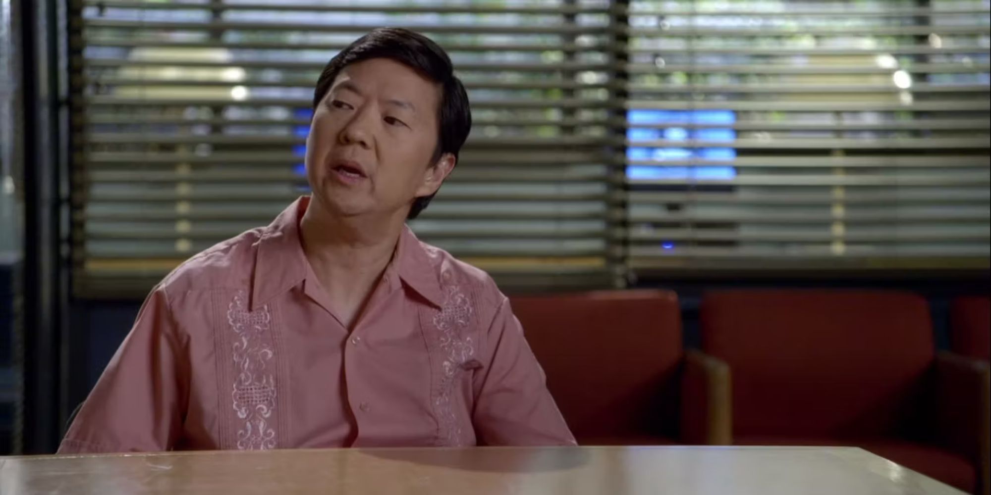 Ben Chang (Ken Jeong) staring to his side, sitting in the study room