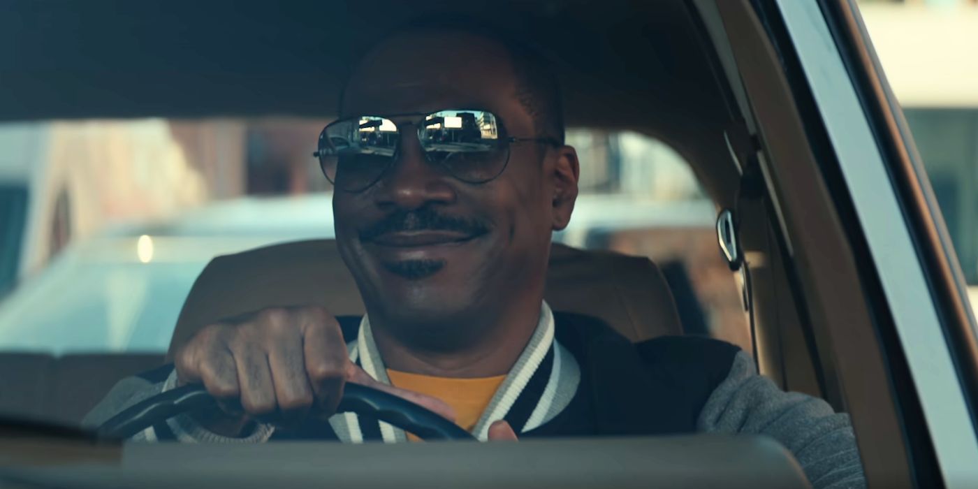 Eddie Murphy as Axel Foley, wearing sunglasses and smiling while driving, in Beverly Hills Cop: Axel F.