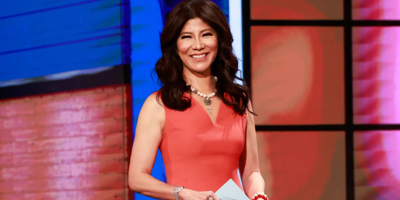 Julie Chen Moonves standing on the set of Big Brother, holding a cue card.