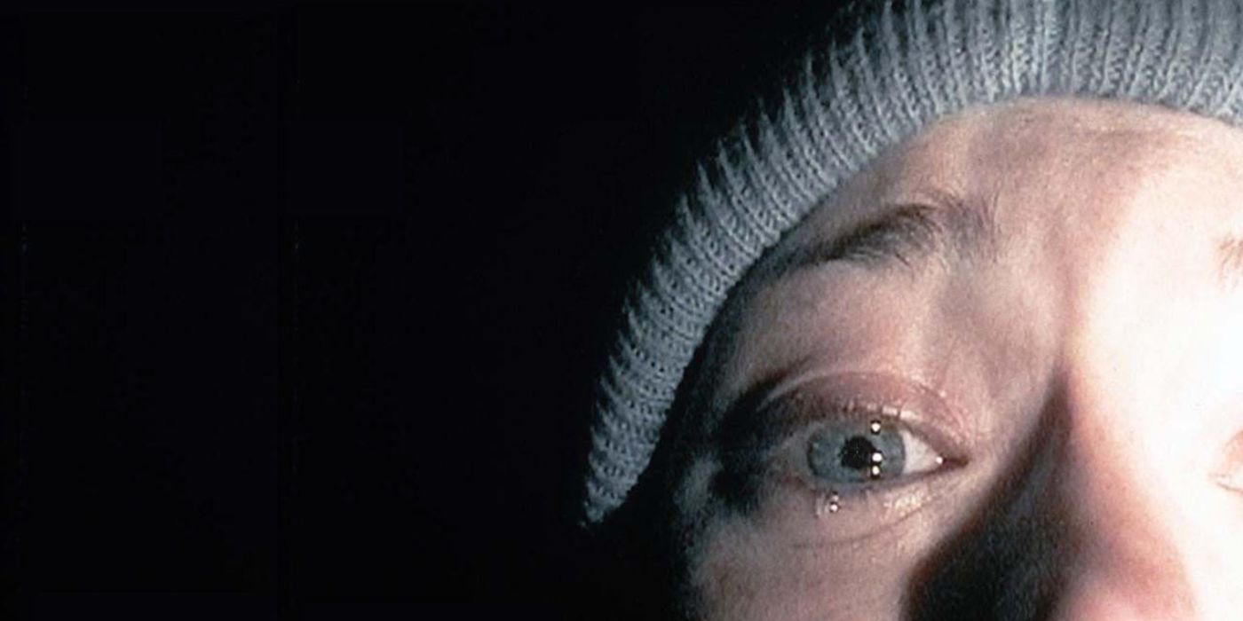 Heather, illuminated by a flashlight, cries into the camera in The Blair Witch Project
