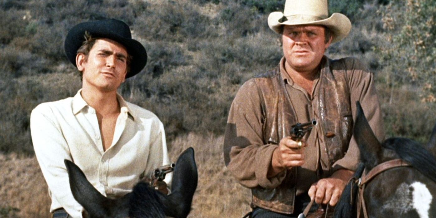 Michael Landon and Dan Blocker as Little Joe and Hoss Cartwright, holding pistols while riding horses in Bonanza