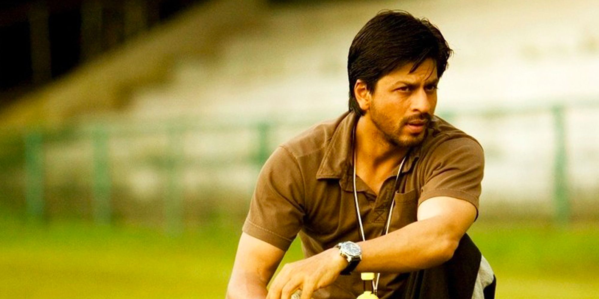 Shah Rukh Khan as Kabir Khan sitting down in a field in Chak De! India 