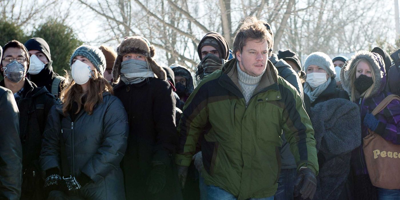 Matt Damon standing next to a group of individuals wearing face masks in Contagion